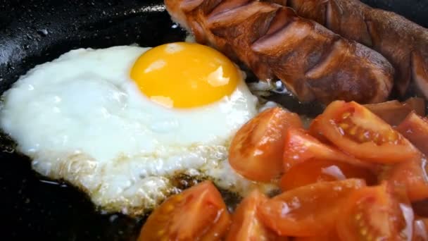 Recette rapide délicieux petit déjeuner traditionnel américain ou anglais. Cuisson des œufs frits avec des saucisses. - Séquence, vidéo