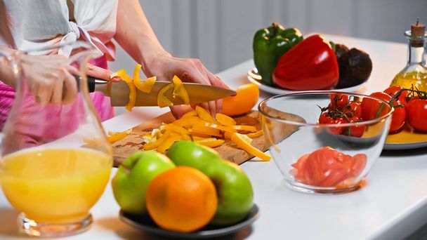 cropped view of woman cutting bell pepper on chopping board - Photo, Image