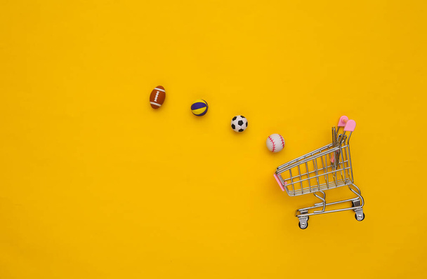 Mini ostoskori eri urheilu pallot keltaisella pohjalla. Yläkuva - Valokuva, kuva