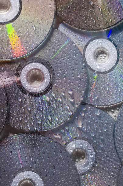Vertical image of shiny and wet CD discs as a background - Photo, Image