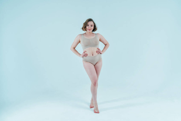 Image of a beautiful woman posing in studio wearing lingerie. Concept about body positivity and self acceptance - 写真・画像