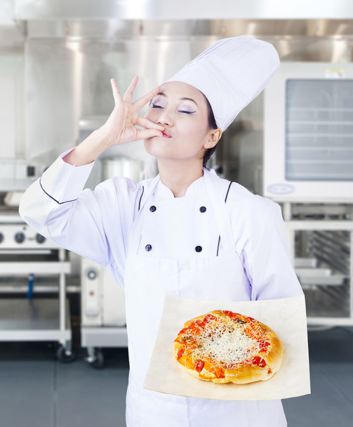 Asian chef and delicious pizza in kitchen - Zdjęcie, obraz