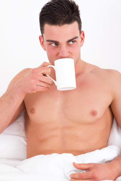 vonzó férfi, az ágyban kávéfogyasztás - Fotó, kép