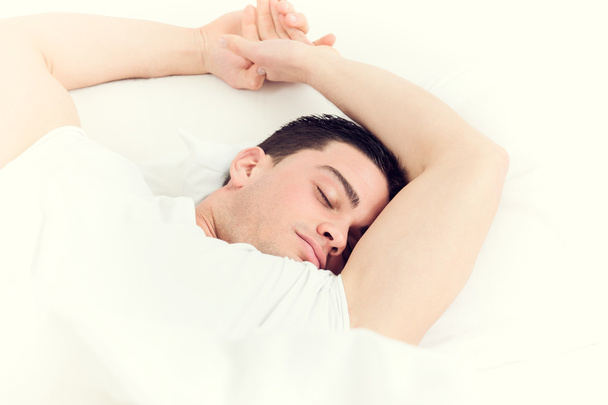 yumuşak beyaz yastıkta uyumak yakışıklı adam fotoğrafı - Fotoğraf, Görsel
