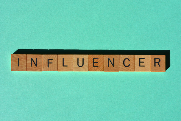 Influencer, parola in lettere alfabetiche di legno isolata su sfondo chiaro come titolo di un banner - Foto, immagini