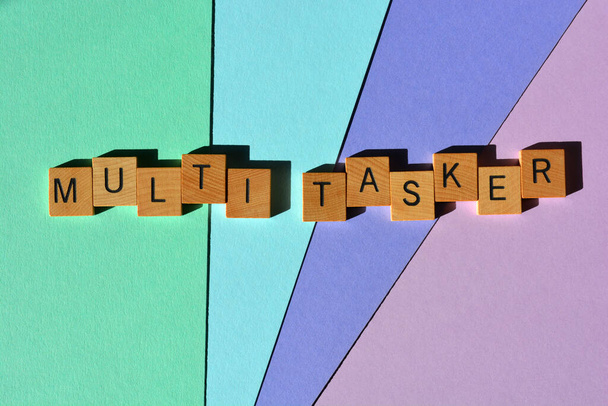 Multi Tasker, palabras en letras de alfabeto de madera aisladas sobre un fondo colorido como titular de la bandera - Foto, imagen