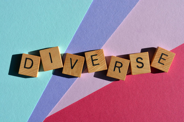 Różnorodność, słowo w drewnianych liter alfabetu izolowane na kolorowym tle - Zdjęcie, obraz