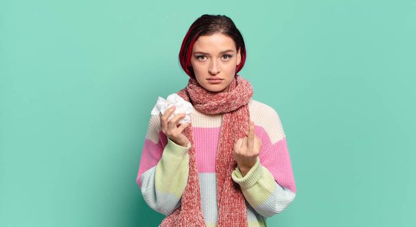 young attractive red hair woman feeling angry, annoyed, rebellious and aggressive, flipping the middle finger, fighting back flu concept - Foto, afbeelding