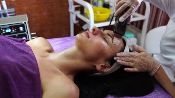Ультразвукове очищення обличчя жінки в центрі СПА. - Кадри, відео