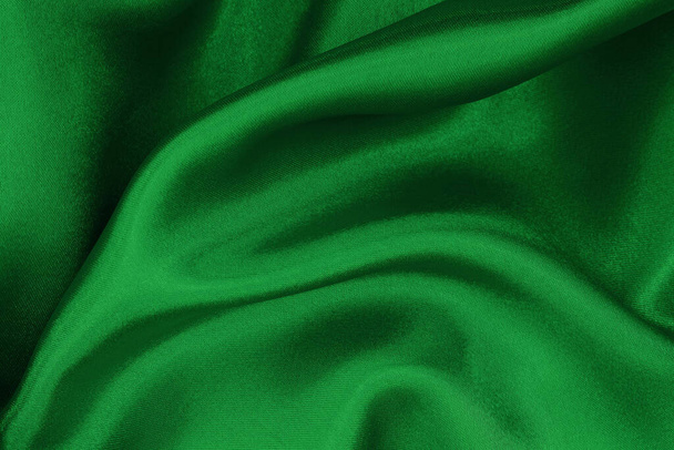 Dunkelgrüne Stofftextur für Hintergrund und Design-Kunstwerke, schöne zerknüllte Muster aus Seide oder Leinen. - Foto, Bild