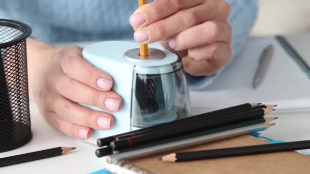 Frau spitzt Bleistifte mit elektrischem Anspitzer im Studio 4k Film - Filmmaterial, Video