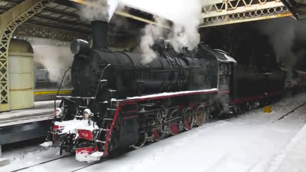 駅、冬時間から始まるヴィンテージ蒸気機関車。乗客がホームに乗るのを待っています - 映像、動画