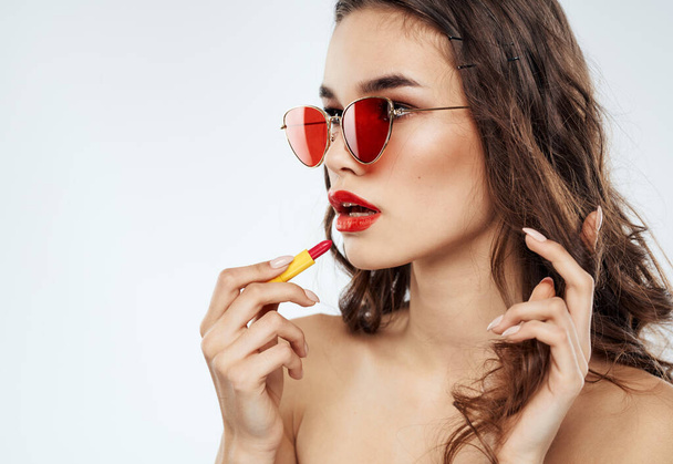 Femme en lunettes de soleil avec rouge à lèvres vue recadrée - Photo, image