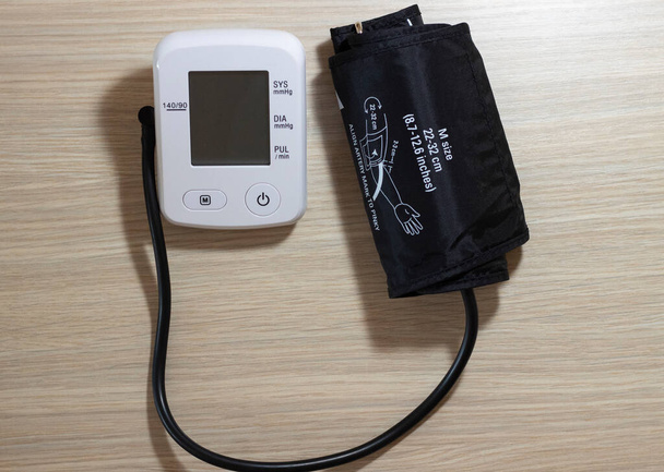 Монитор кровяного давления с наручниками вблизи с макетом - Фото, изображение