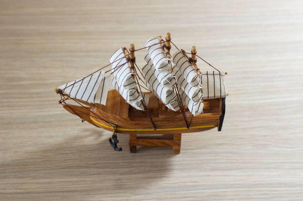 Szuvenír fából készült hajó elkülönített közelsége könnyű fából készült háttéren - Fotó, kép