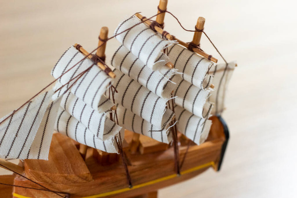 Изолированный крупным планом сувенирный деревянный корабль на светлом деревянном фоне - Фото, изображение