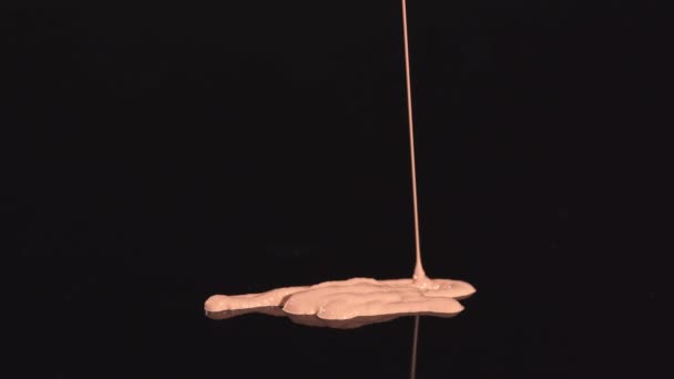 time lapse di fondazione trucco beige che perde su sfondo nero - Filmati, video