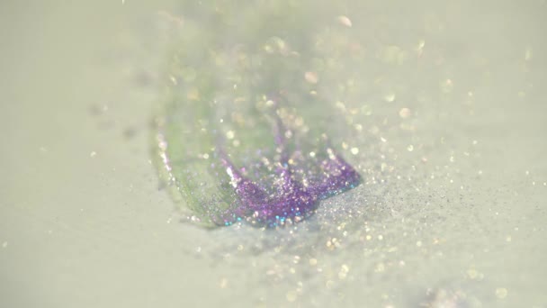 primo piano di polvere lucida che cade su ombretto viola su sfondo bianco - Filmati, video