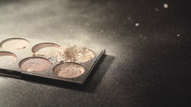 cosmetic powder falling on crushed compact eye shadow on black - Footage, Video