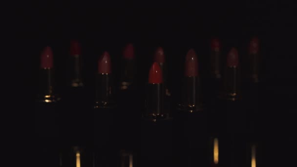 Beleuchtung auf Palette verschiedener Lippenstifte isoliert auf schwarz - Filmmaterial, Video