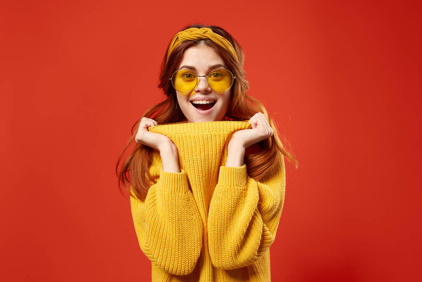 hezká žena nosí brýle žlutý svetr emoce ležérní nosit červené pozadí - Fotografie, Obrázek