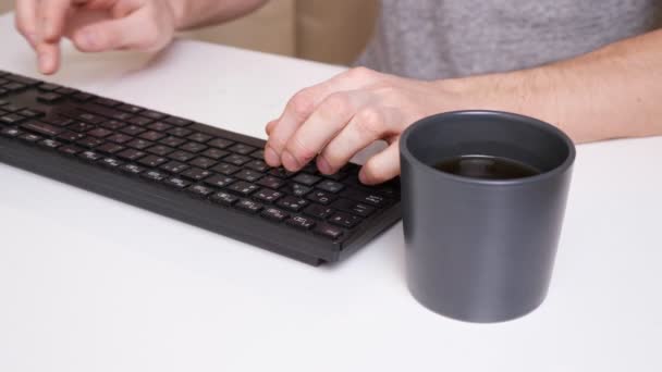 Nerozpoznatelný muž psaní na klávesnici počítače a házení kávy na něj - Záběry, video