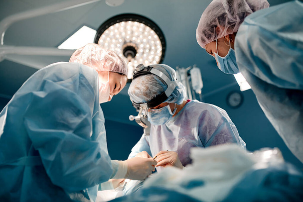Un equipo de cirujanos está luchando por la vida, por una operación real, por emociones reales. El equipo de cuidados intensivos está luchando por la vida del paciente. Salvar la vida, la lucha por la vida - Foto, Imagen