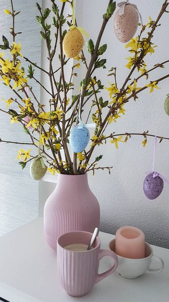пастельна кольорова ваза з покинутими та великодніми яйцями та рожевою чашкою кави
 - Фото, зображення