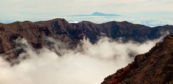 Působivá panoramatická krajina mraků a sopečných hor z vrcholu Roque de los Muchachos, na ostrově La Palma, Kanárské ostrovy, Španělsko. - Fotografie, Obrázek