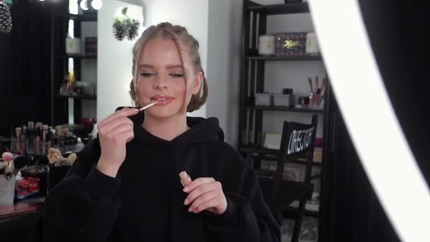 Όμορφη ξανθιά blogger μαλλιά εφαρμόζει κραγιόν. Γυναίκα κάνει ένα βίντεο για το blog της - Πλάνα, βίντεο
