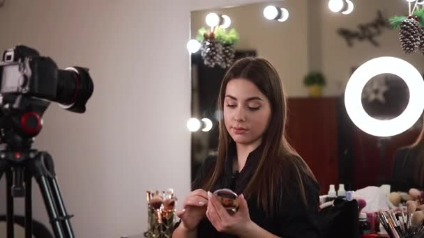 Profession maquilleuse femme examinant les produits de beauté sur un blog vidéo au studio de beauté. Femme utiliser lampe anneau - Séquence, vidéo