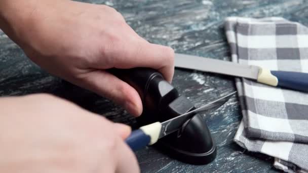 Schleifen Sie ein Küchenmesser mit einem Schleifstein. Haushaltsmesser schleifen. - Filmmaterial, Video