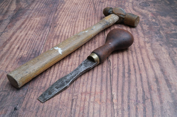 Norwich, Norfolk, UK - 24 січня 2020. Закріплений старий молоток з іржавою головою і дерев'яною ручкою, і традиційний дерев'яний зуб на сільській дерев'яній лавці. - Фото, зображення