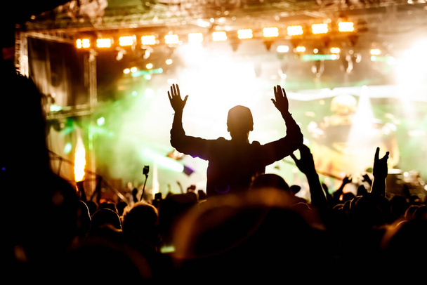 Concerto rock, silhouette di persone felici alzano le mani - Foto, immagini