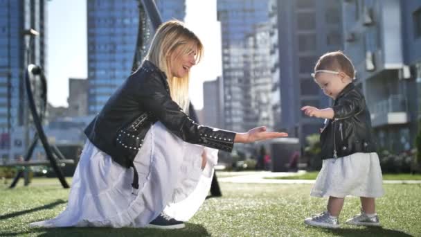Menina da criança bonito e mãe brincando no parque urbano - Filmagem, Vídeo