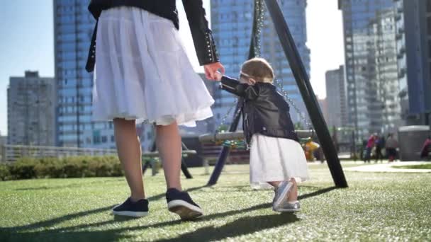 Malá dívka chůze držení maminky ruku venku - Záběry, video