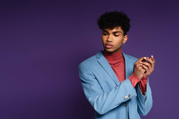 hombre afroamericano en chaqueta azul mirando hacia otro lado en púrpura - Foto, Imagen