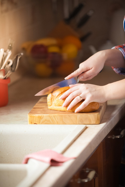 Photo of woman cutting bread on wooden desk - Photo, Image