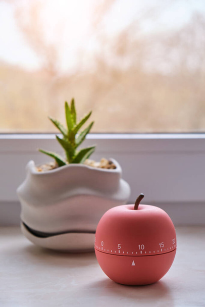 Moderno timer a forma di mela accanto alle finestre con calda illuminazione all'alba, timer a campana - piccolo aiuto in cucina - Foto, immagini
