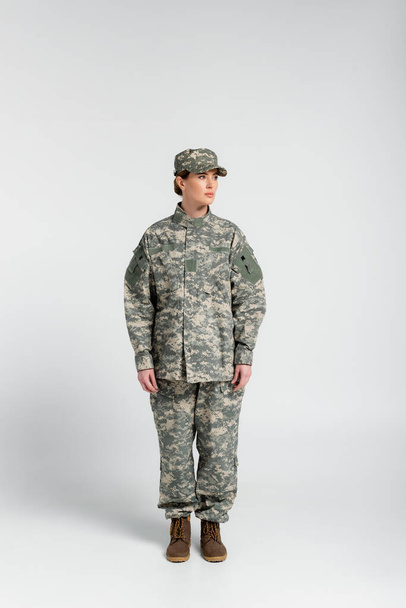 Full length of soldier in military uniform standing on grey background  - Φωτογραφία, εικόνα