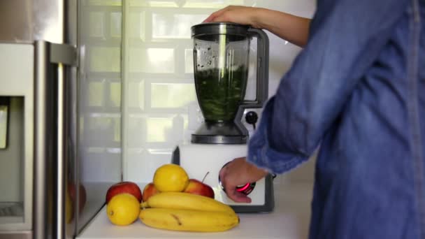 Donna mescolando spinaci, banane, limone e mele per fare un frullato verde sano. Concetto di vita sano - Filmati, video