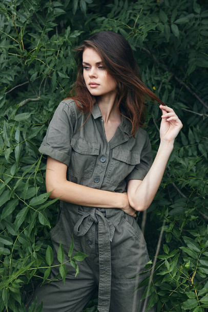 Woman tourist loneliness outdoor walks green overalls against the background  - Foto, Imagen