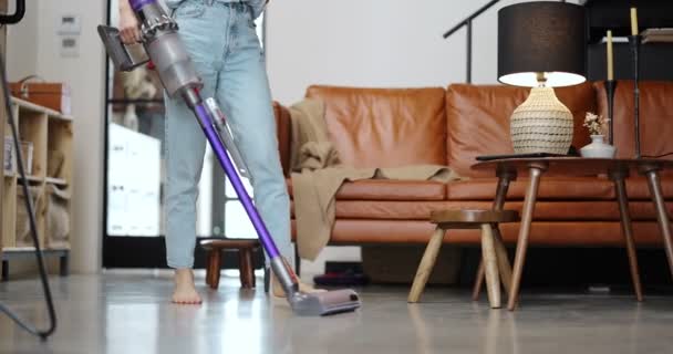 Mujer aspirando piso con limpiador inalámbrico - Metraje, vídeo
