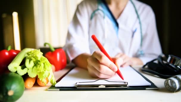 Koncept výživy a medikace zeleniny. Nutriční lékař píše předpis a nabízí zdravou zeleninu strava. - Záběry, video