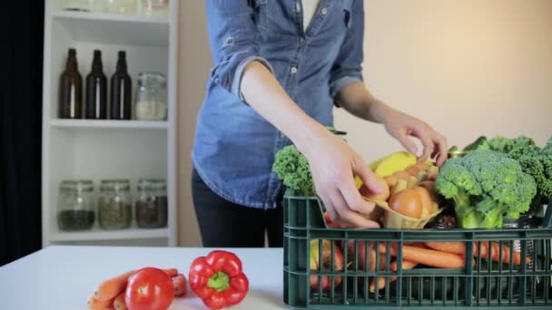 Servicio de entrega de alimentos - mujer con caja de comestibles sobre fondo gris - Imágenes, Vídeo