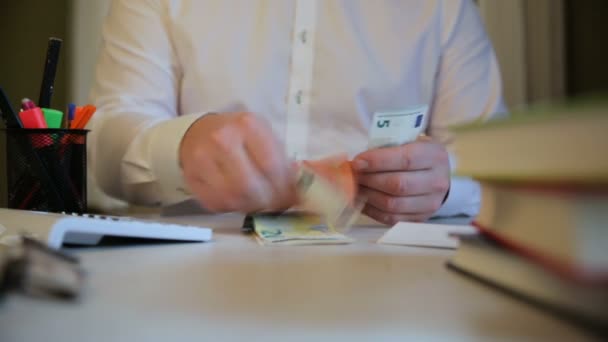 Mies laittaa lahjuksia kirjekuoreen, rahaa kirjekuoreen korruption symbolina. lahjusten ottaminen, rikollinen toiminta, palkka kirjekuoressa veronmaksun välttämiseksi - Materiaali, video