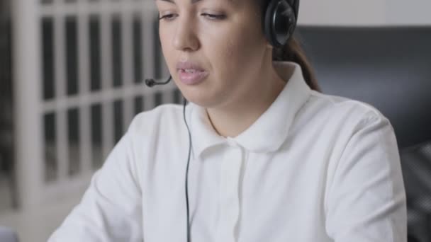 Γυναίκα τηλεφωνητή κέντρο, πράκτορας υποστήριξης πελατών φοράει ακουστικά συμβουλεύει τον πελάτη σε απευθείας σύνδεση, πληκτρολογώντας στο laptop, μιλάμε στο διαδίκτυο συνομιλία στον υπολογιστή, τηλεφωνήτρια γραμμή βοήθειας γραμματέας κάνουν τηλεδιάσκεψη κλήση βίντεο - Πλάνα, βίντεο
