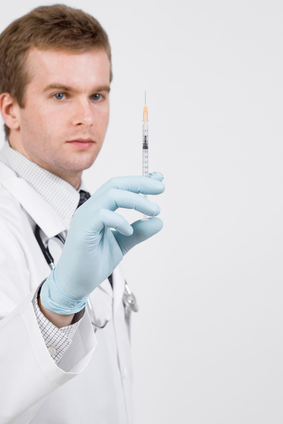 Doctor with medical syringe in hand ready to make injection - Foto, afbeelding
