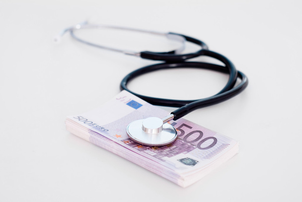 Stethoscope with money  on table - Foto, afbeelding