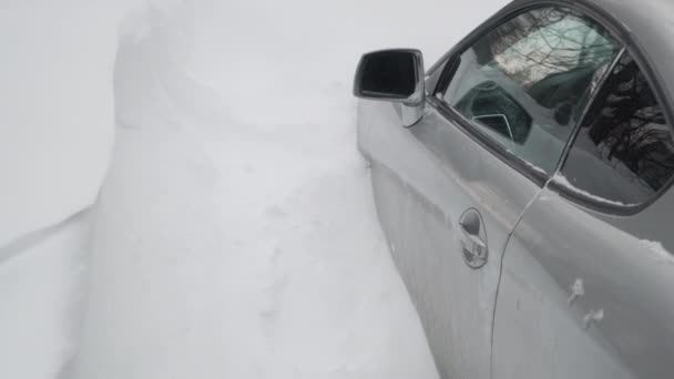 Osobní auto, jeho kapota pohřbená ve sněhu. Dveře auta jsou také zablokovány sněhovou závějí - Záběry, video